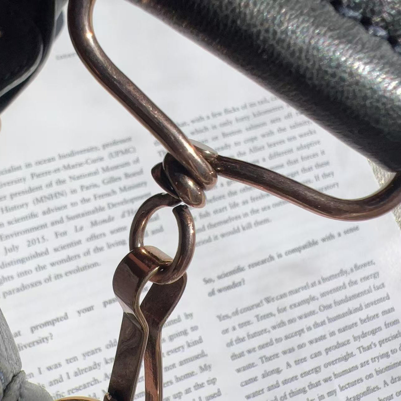 Close-up of a leather bag handle with a keychain on a book page background