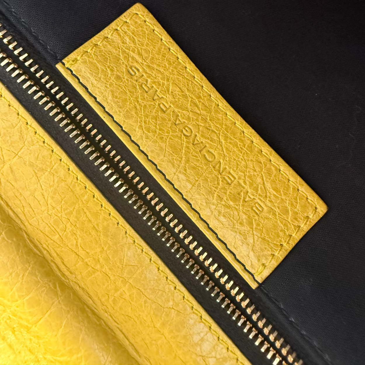 Close-up of a yellow leather patch with text on a black background