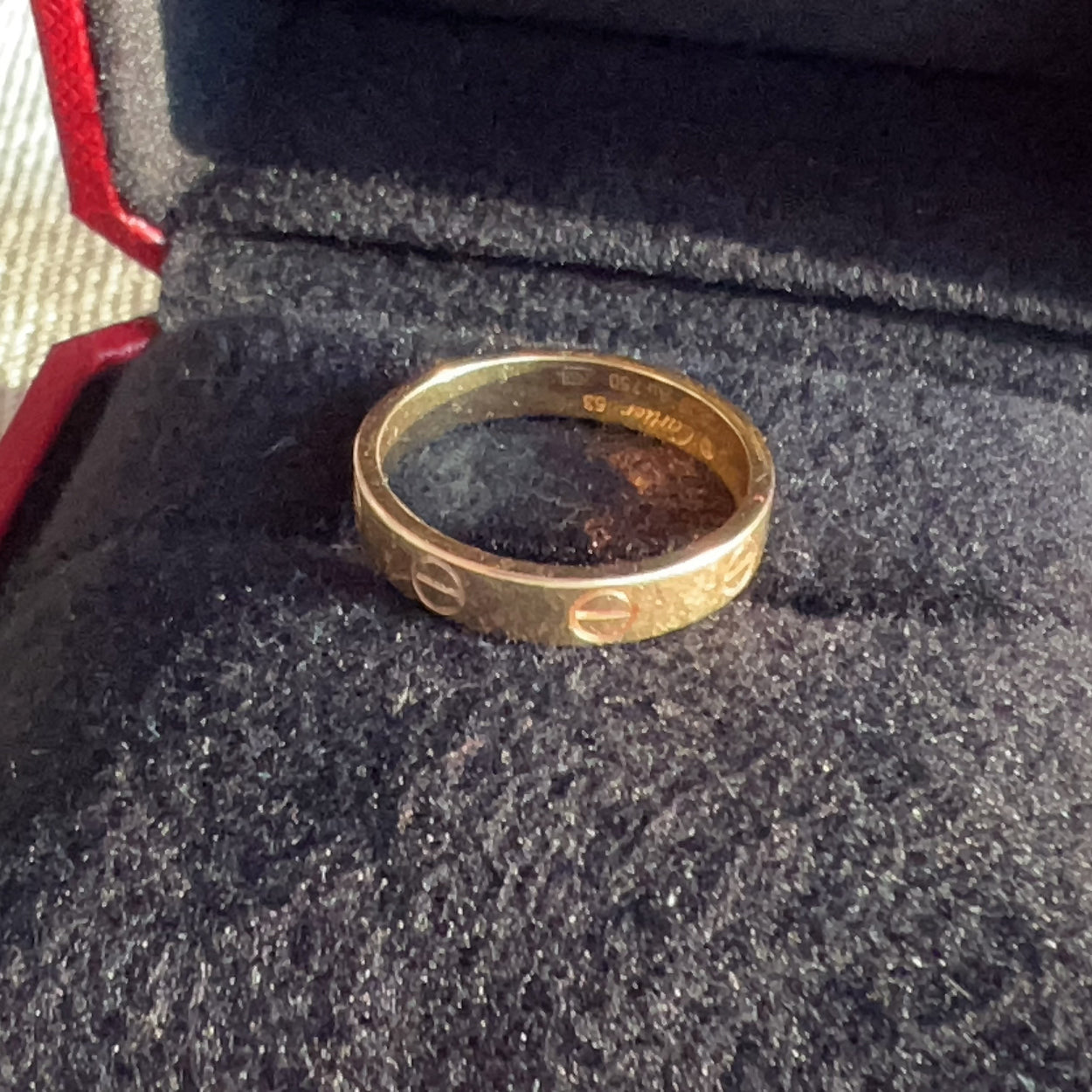 Gold ring with engraved text on a textured surface