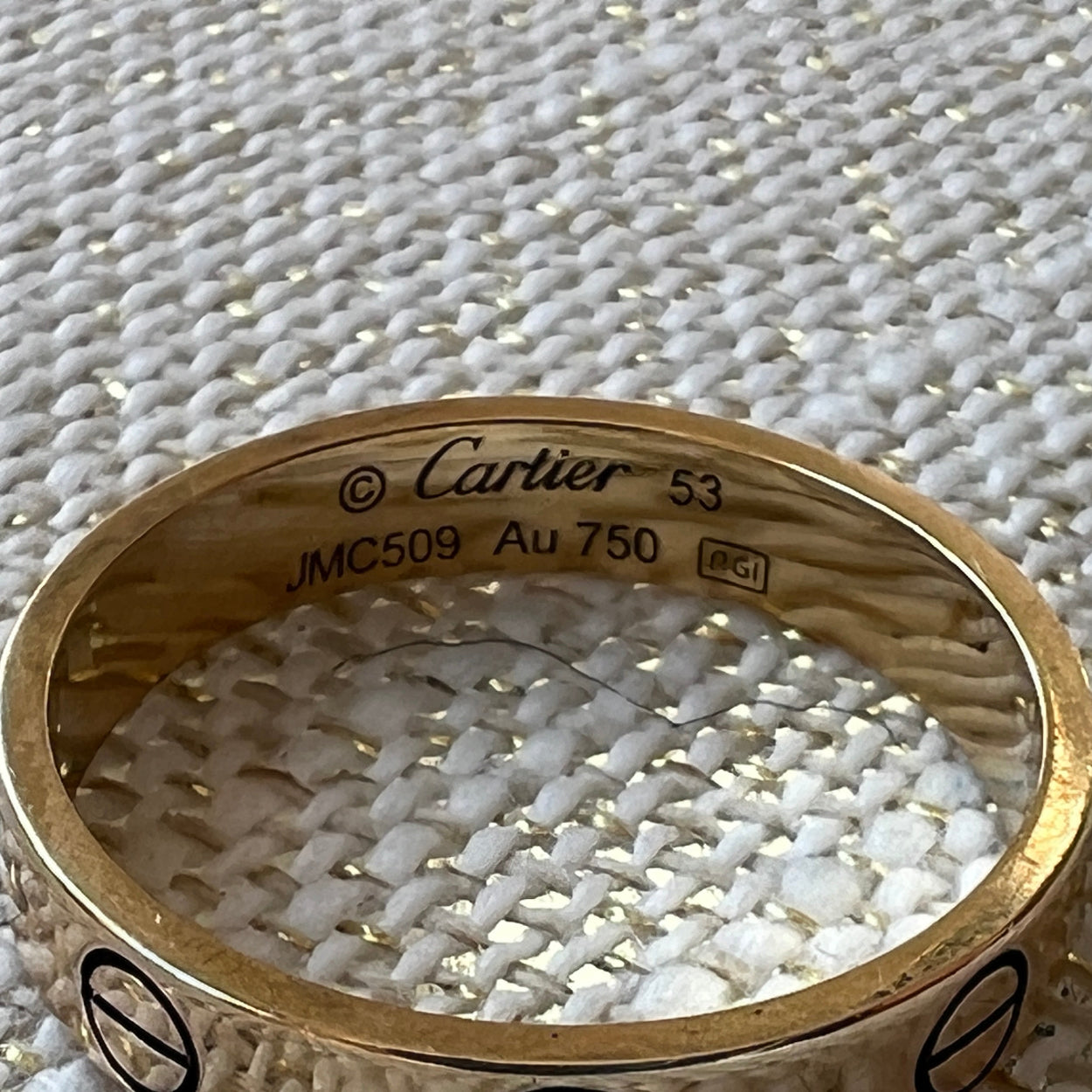 Gold Cartier ring on a textured white surface