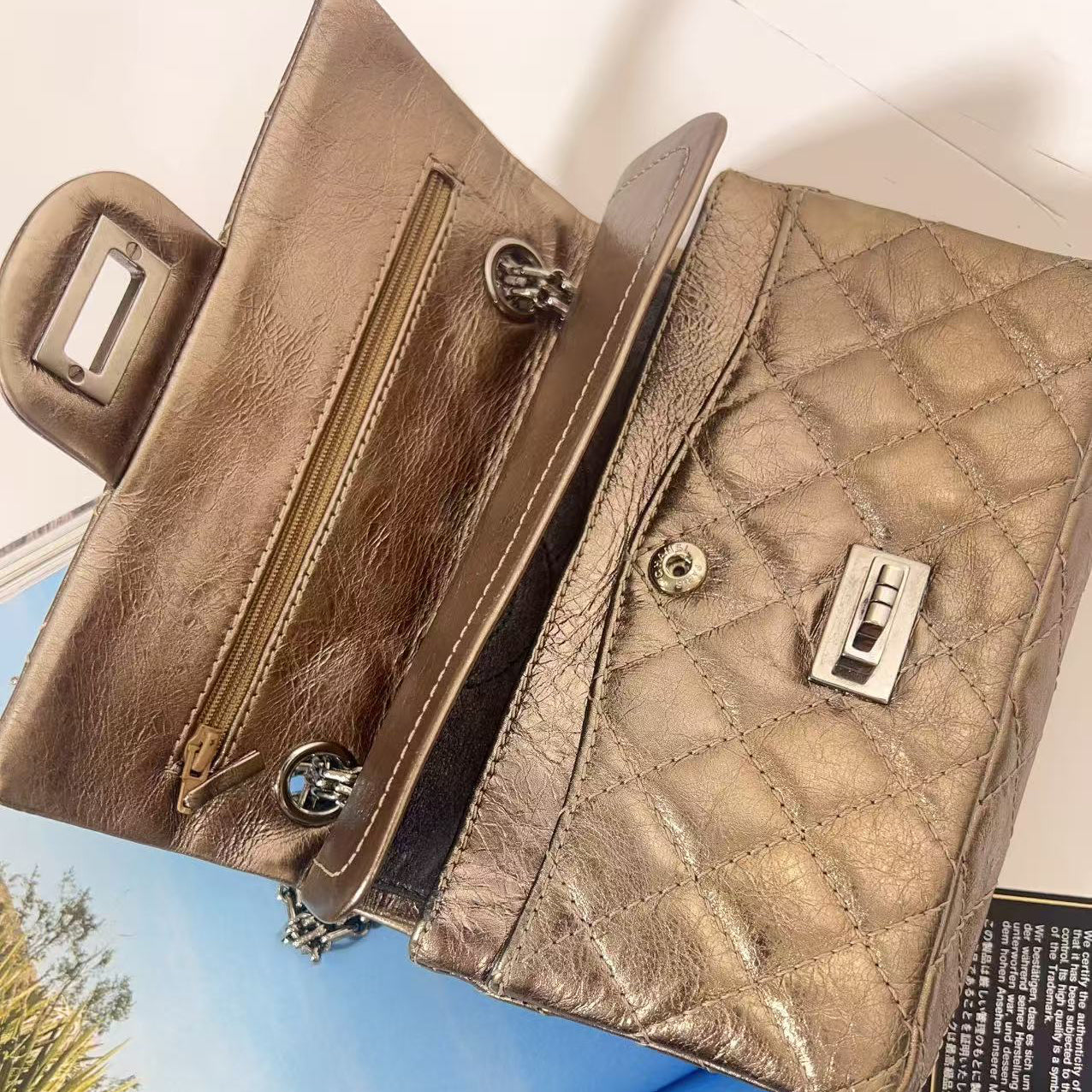 Brown leather handbag with a textured pattern on a magazine background