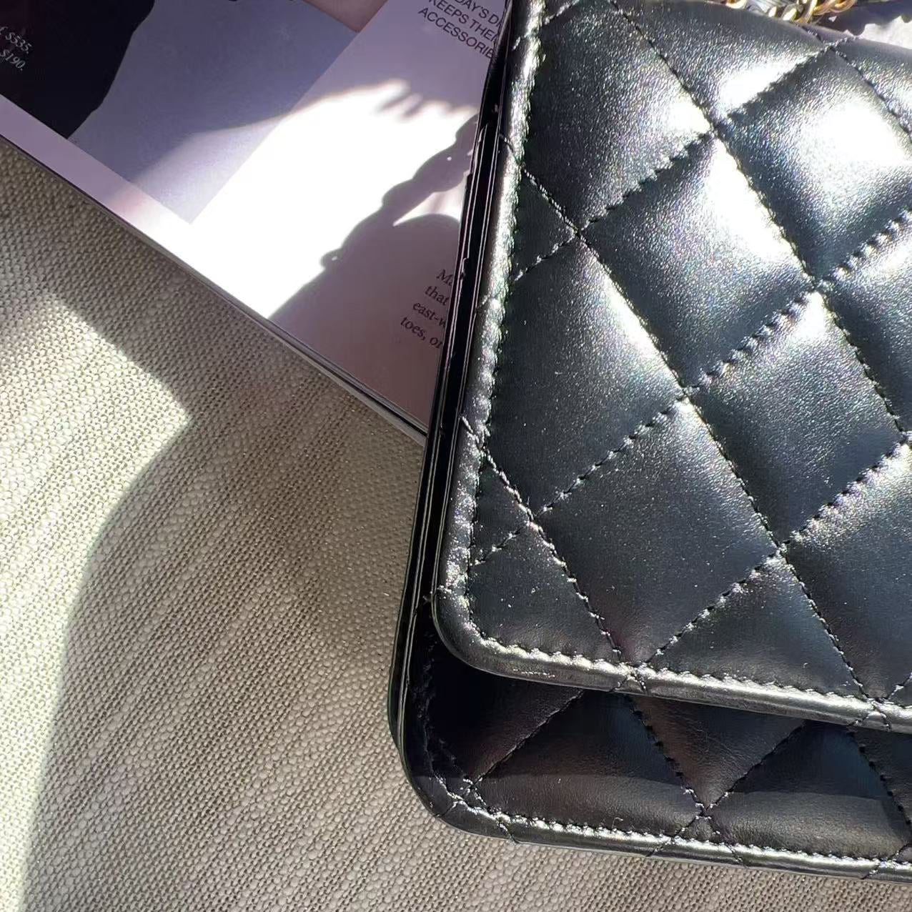 Black quilted wallet on a textured surface