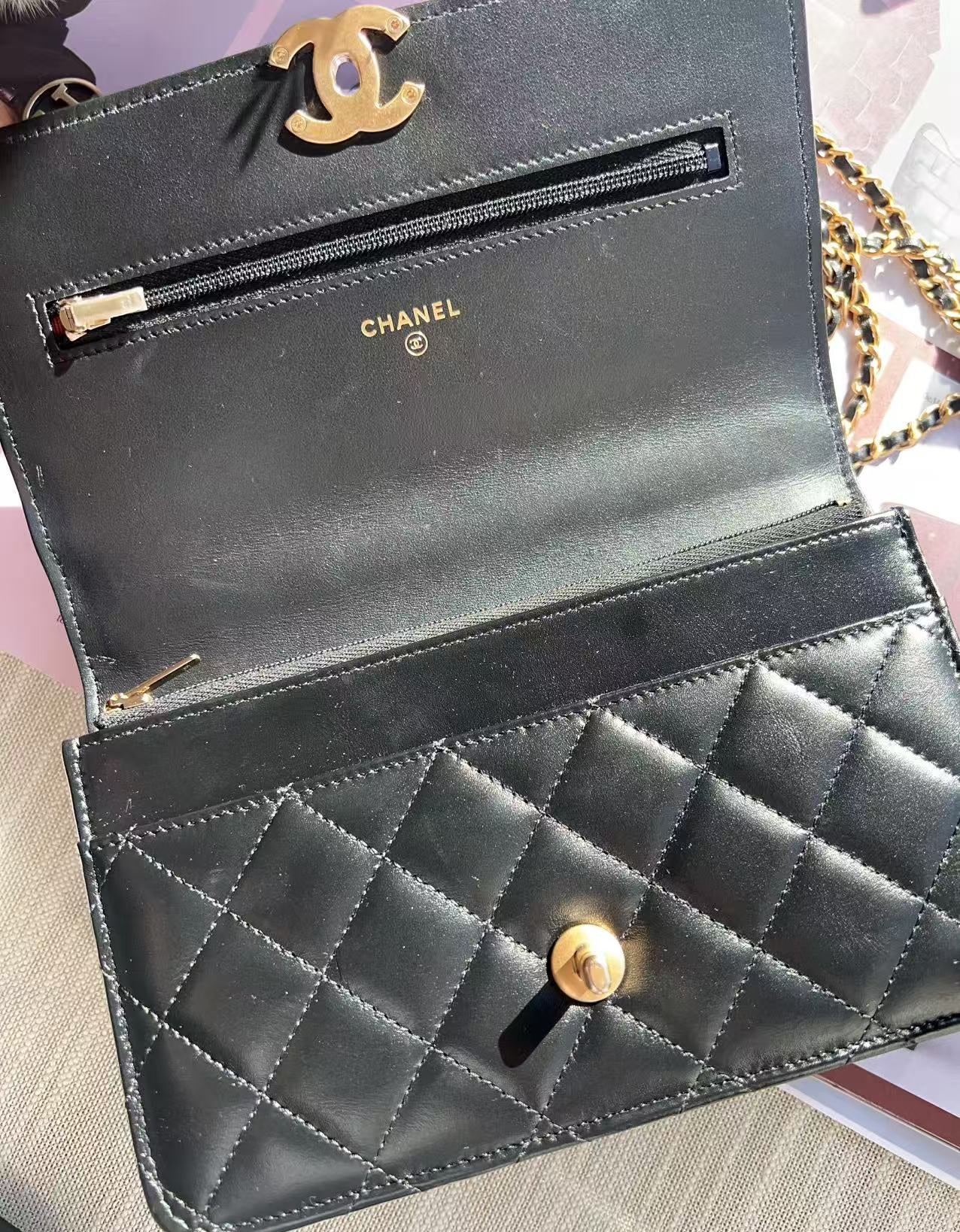 Black quilted Chanel wallet on a textured surface