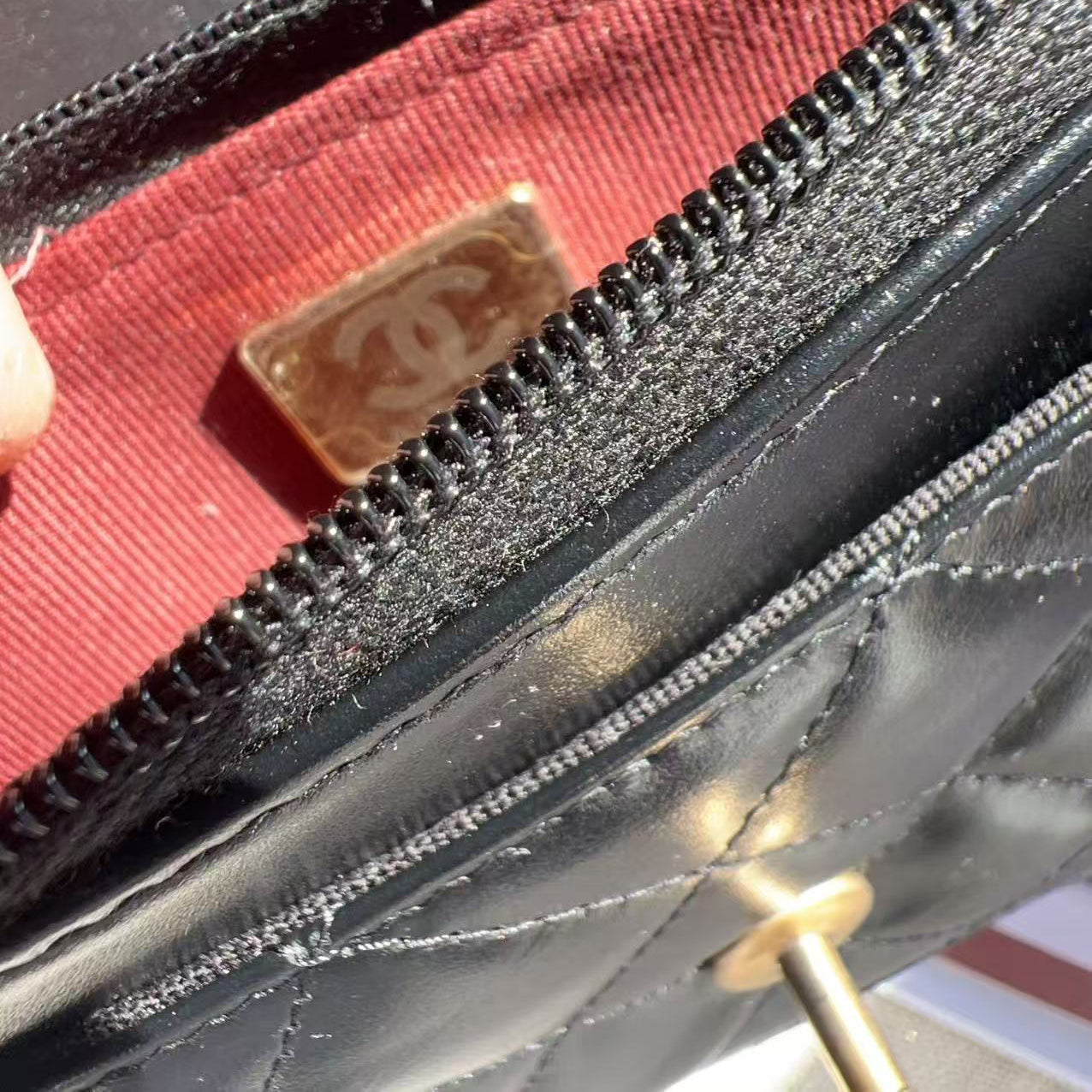 Close-up of a Chanel wallet with a red interior and gold logo.