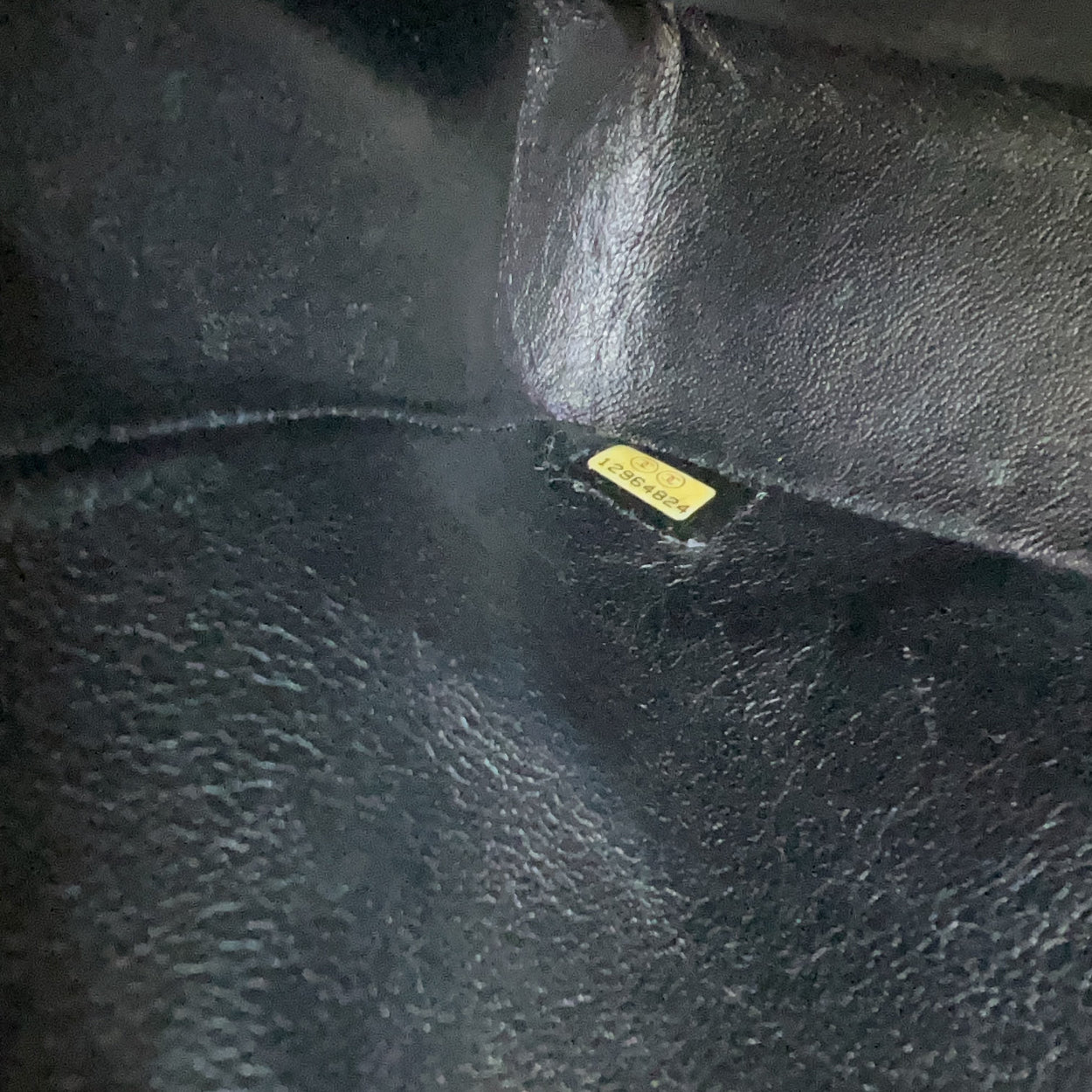 Close-up of a black leather surface with a visible brand label.