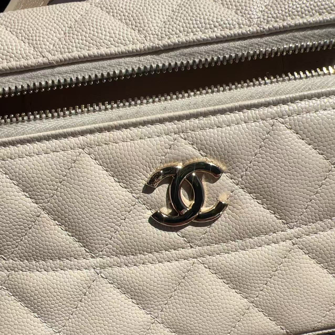 Close-up of a beige quilted handbag with Chanel logo