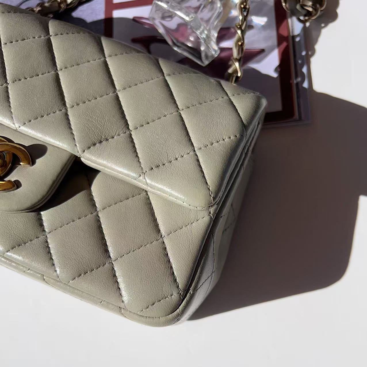 Quilted beige handbag with gold hardware on a light background