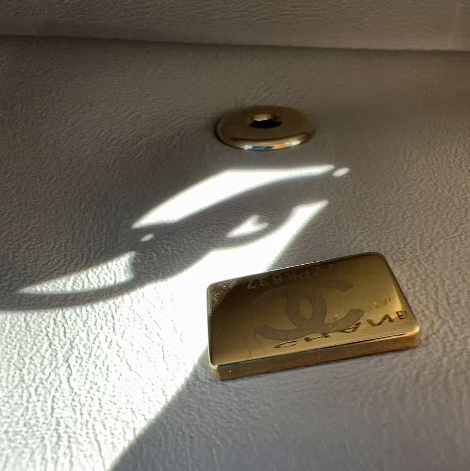 Close-up of a Chanel logo on a white leather surface