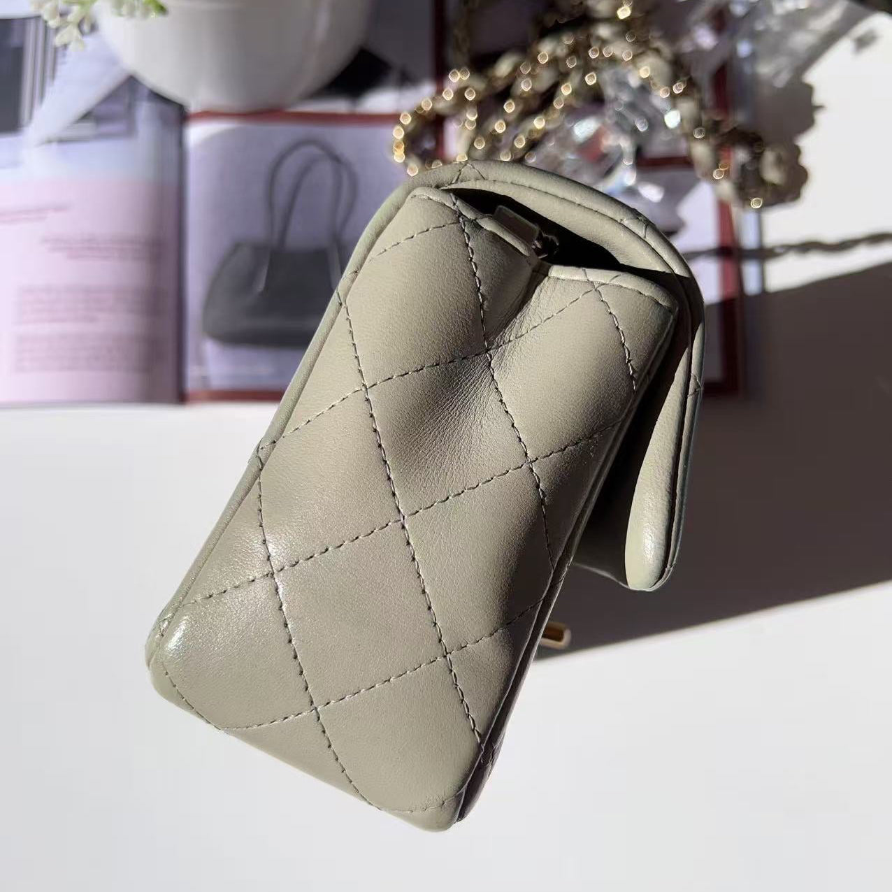Beige quilted wallet on a white surface with blurred background