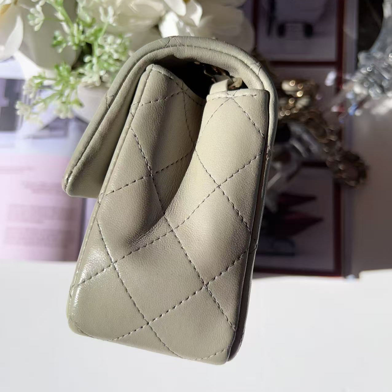Quilted beige wallet on a white surface with a blurred background