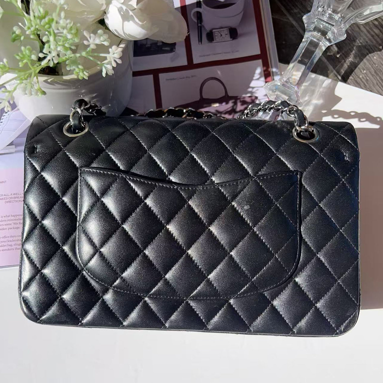 Black quilted handbag on a white surface