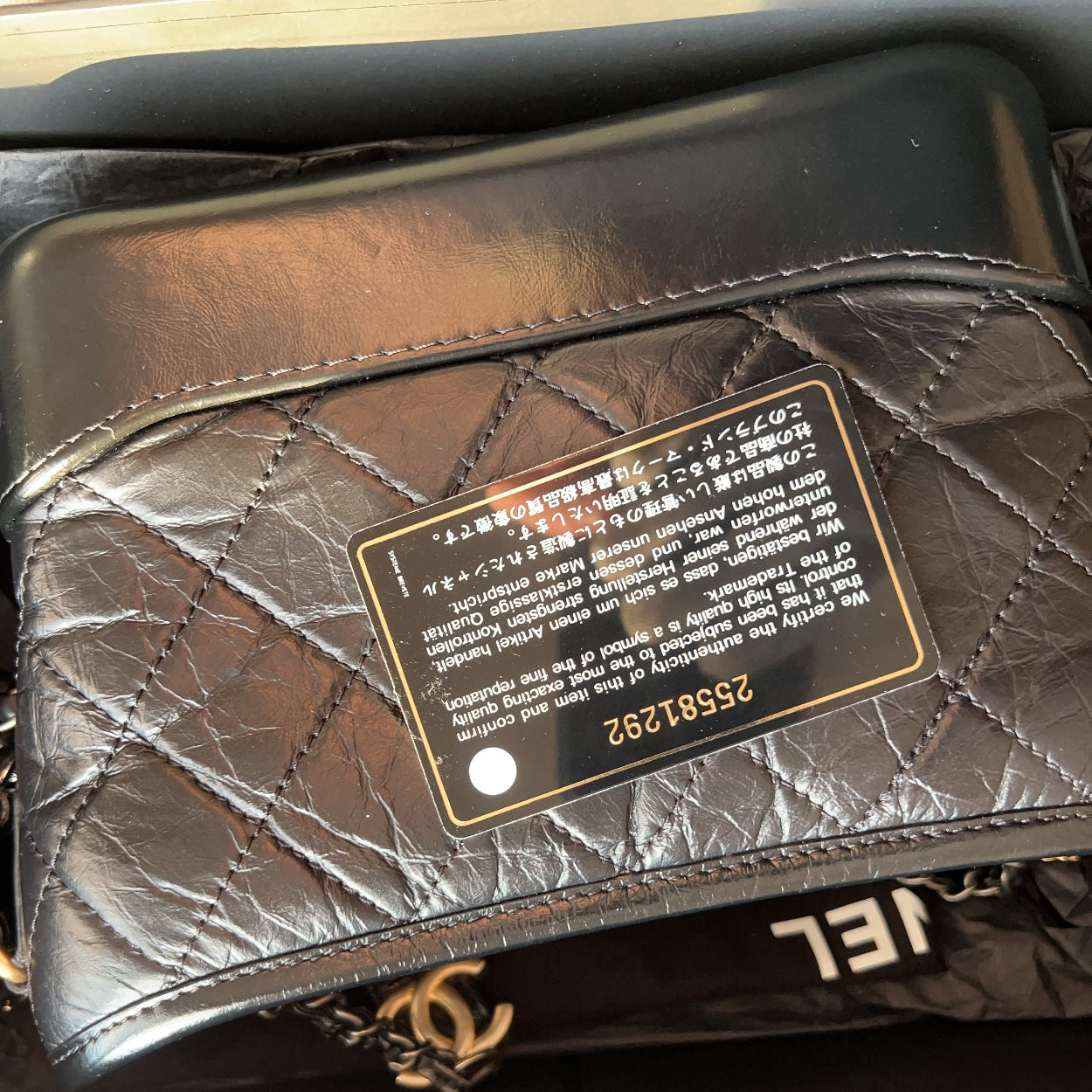 Quilted leather handbag with brand label on a reflective surface