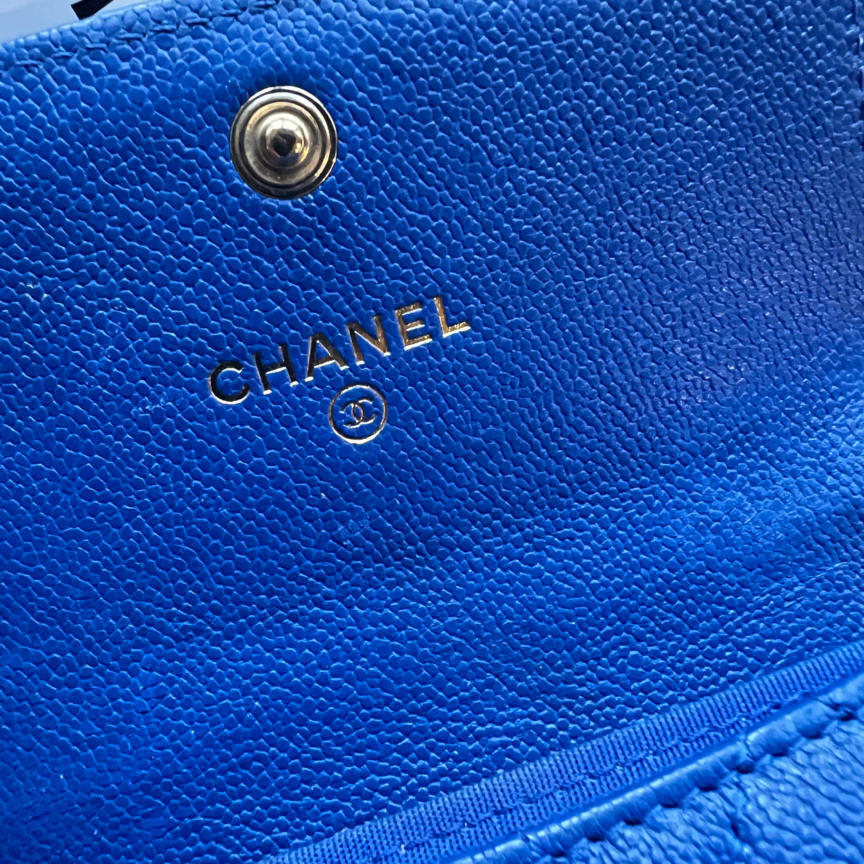 Chanel Close-up of a blue Chanel wallet with the brand logo.