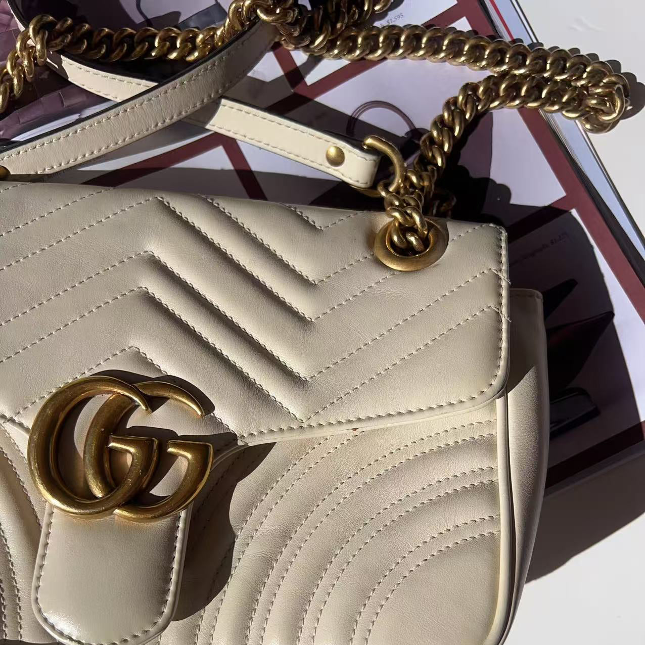 Beige handbag with gold chain and Gucci logo