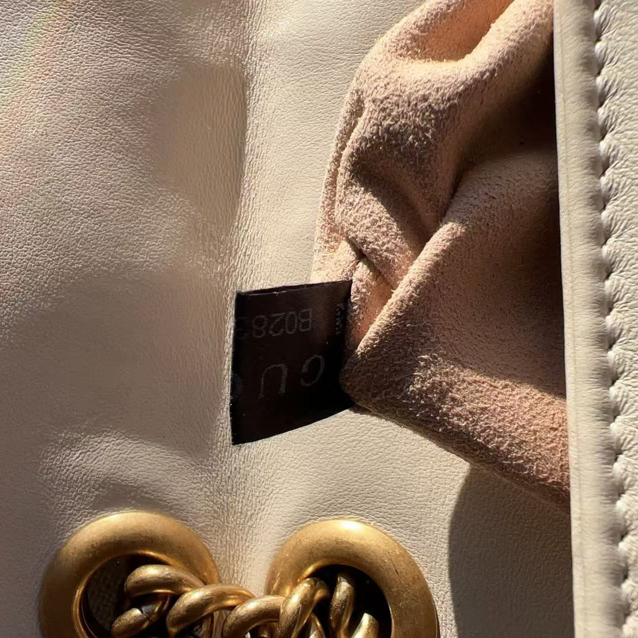 Close-up of a textured surface with a gold clasp and a black label.