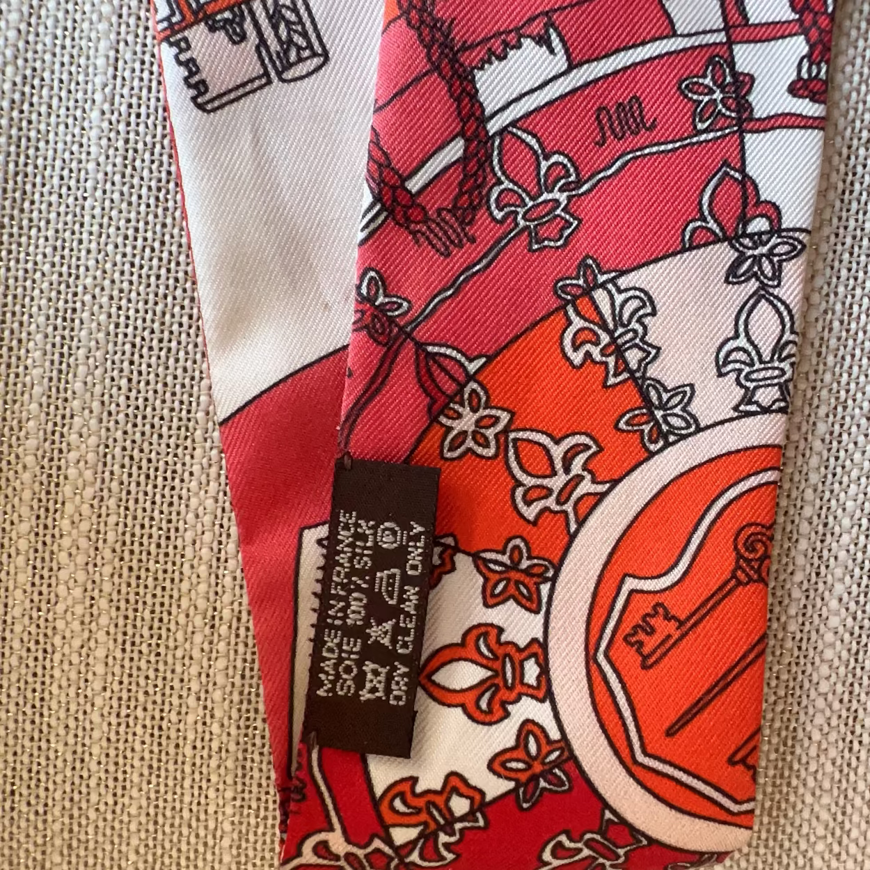 Red and white patterned fabric with a label on a beige background