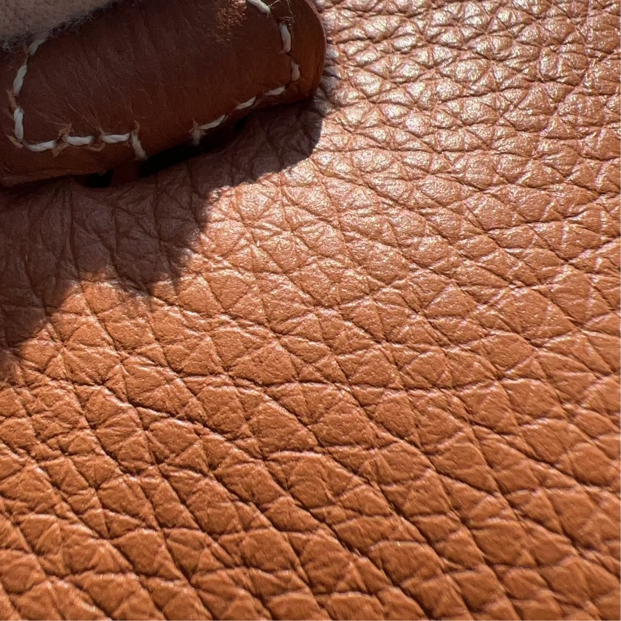 Close-up of a brown leather bag with white fabric underneath