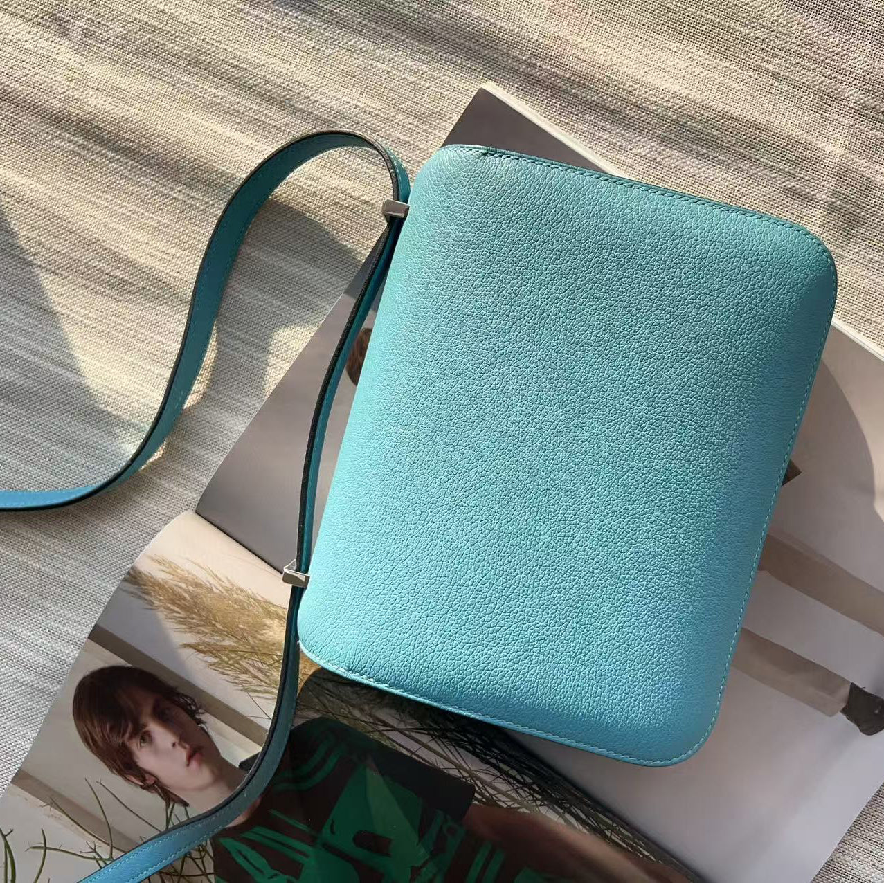 Blue crossbody bag on a magazine