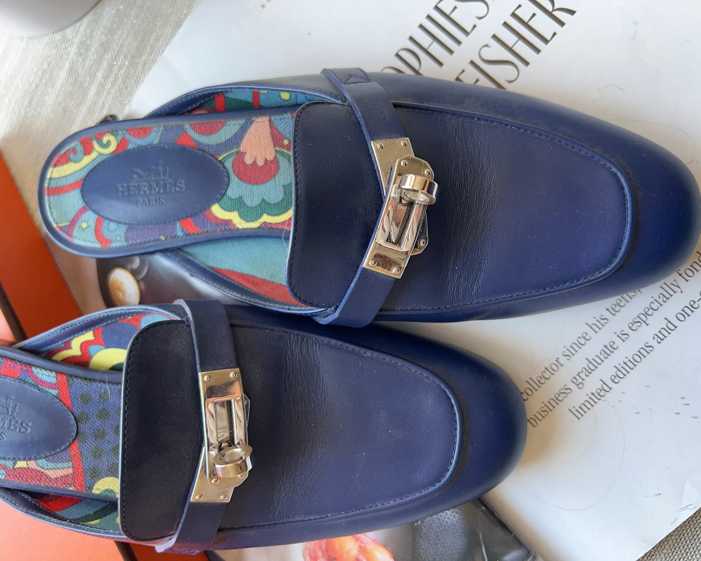 Navy blue sandals with colorful strap on a magazine
