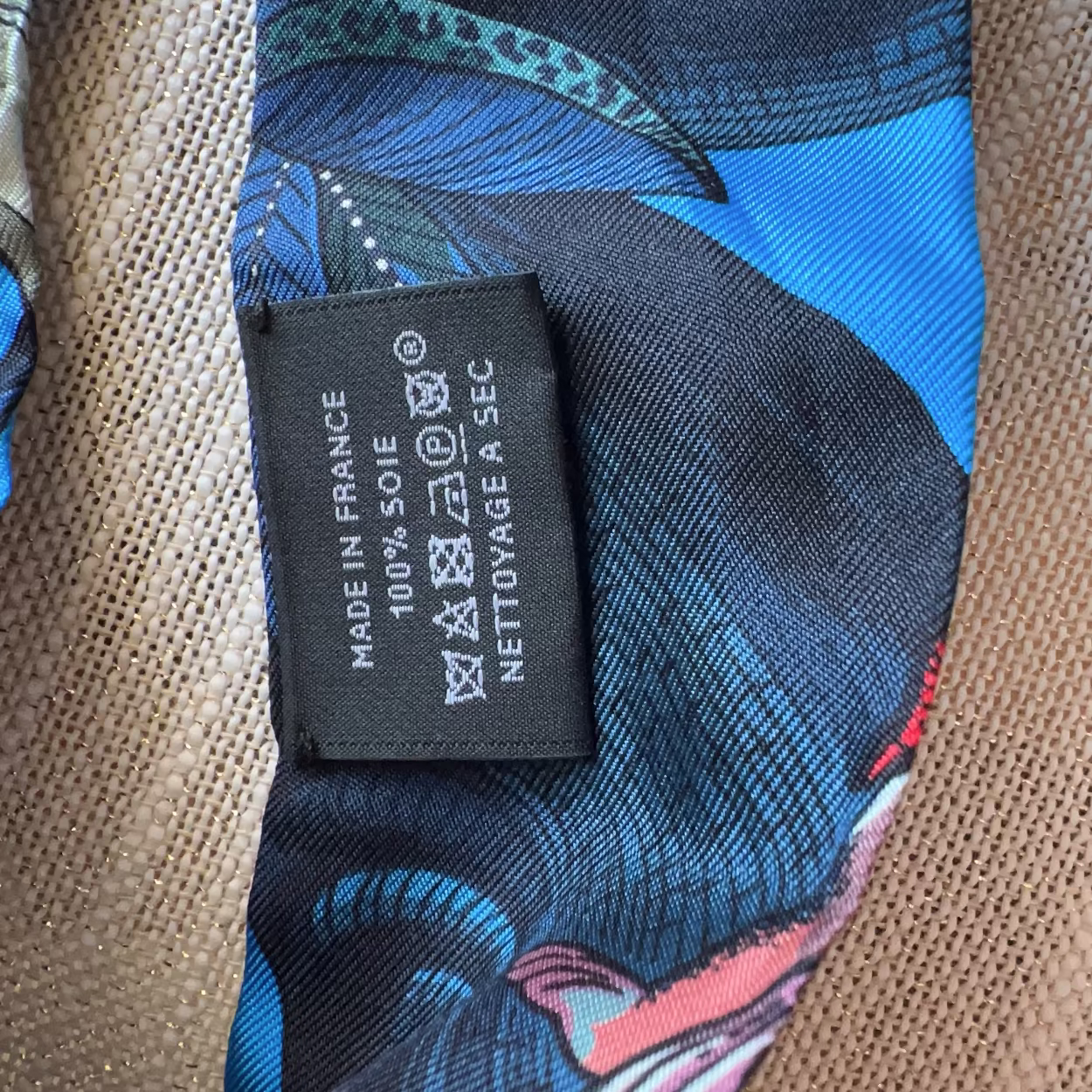 Close-up of a patterned tie with a label on a textured surface