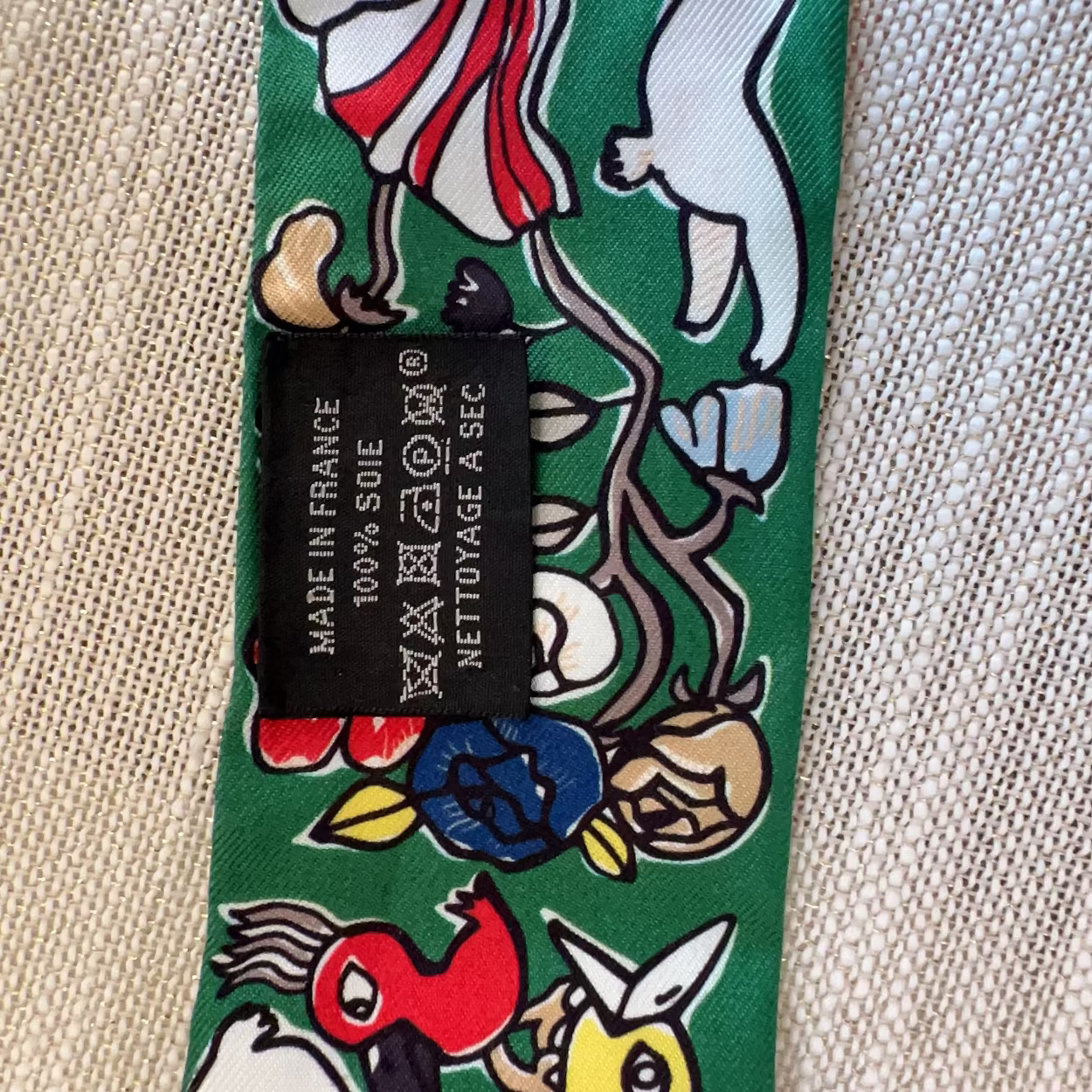 Tie with cartoon character design and brand label on a textured fabric background