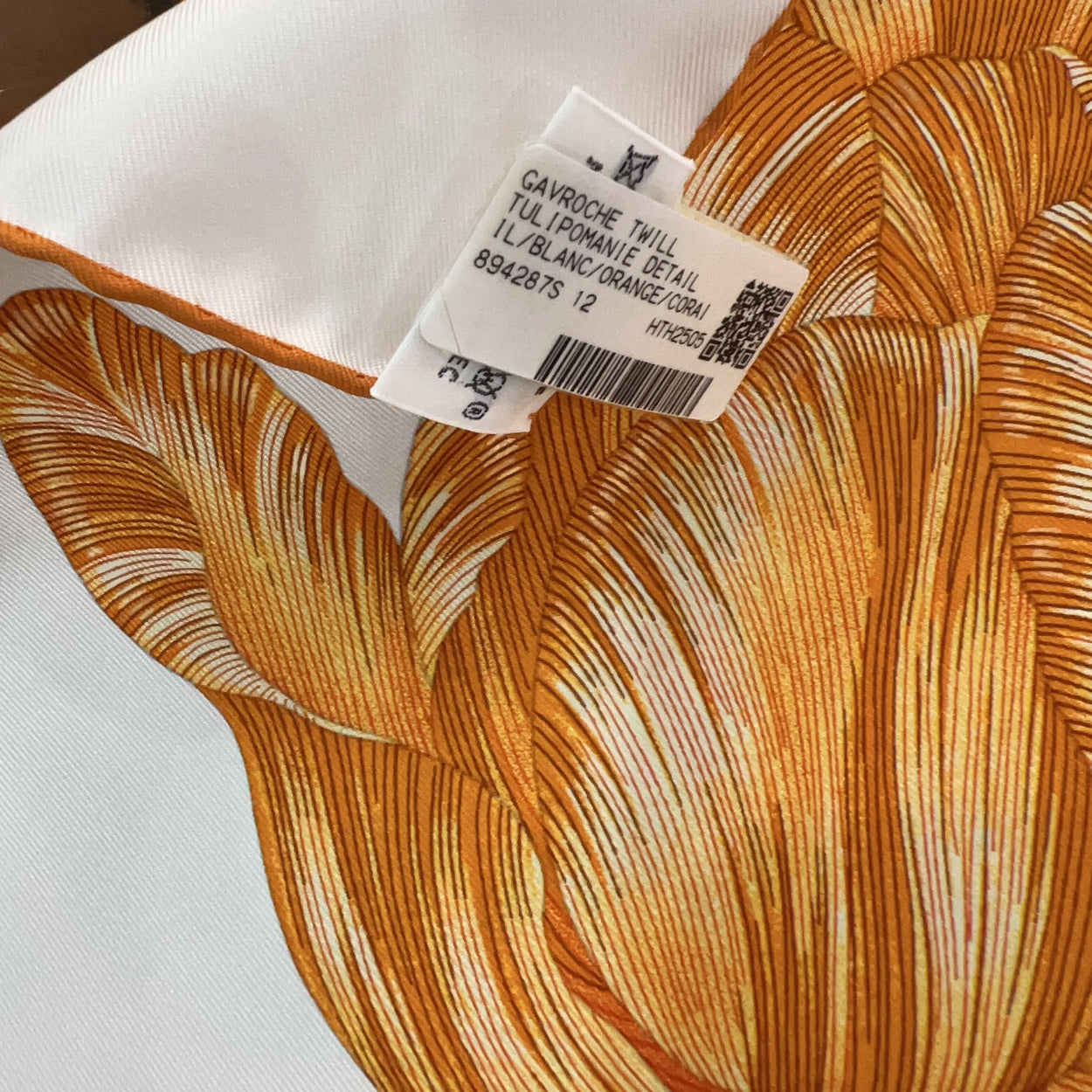 Fabric with orange and white pattern and a label on an orange background