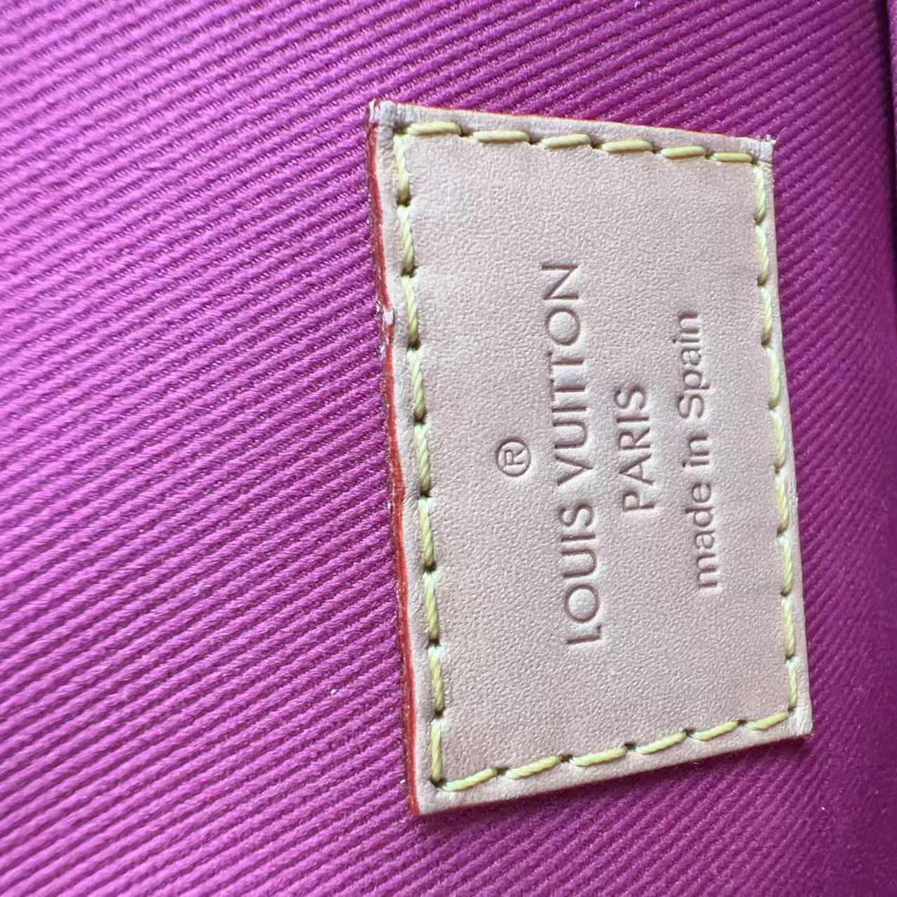 Louis Vuitton label on a purple textured surface