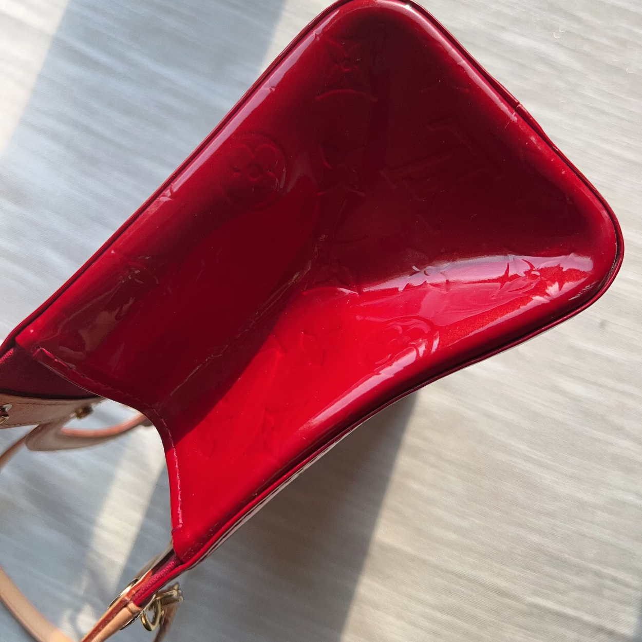 Red handbag on a light wooden surface