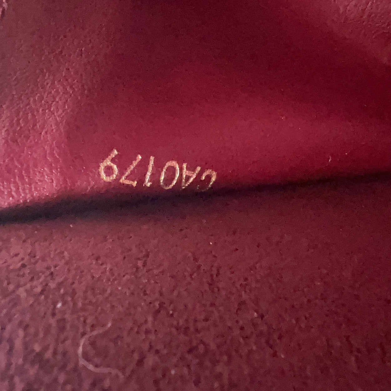 Close-up of a maroon fabric with a visible label number '40179' on a dark background.