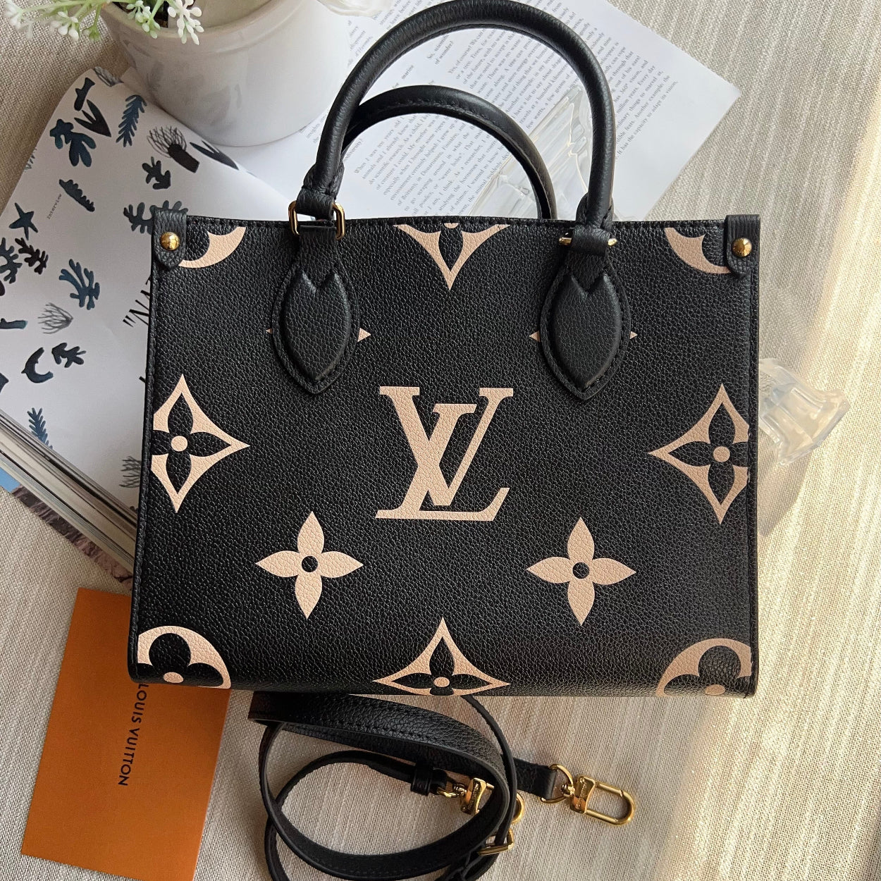 Louis Vuitton handbag with monogram pattern on a light wooden surface
