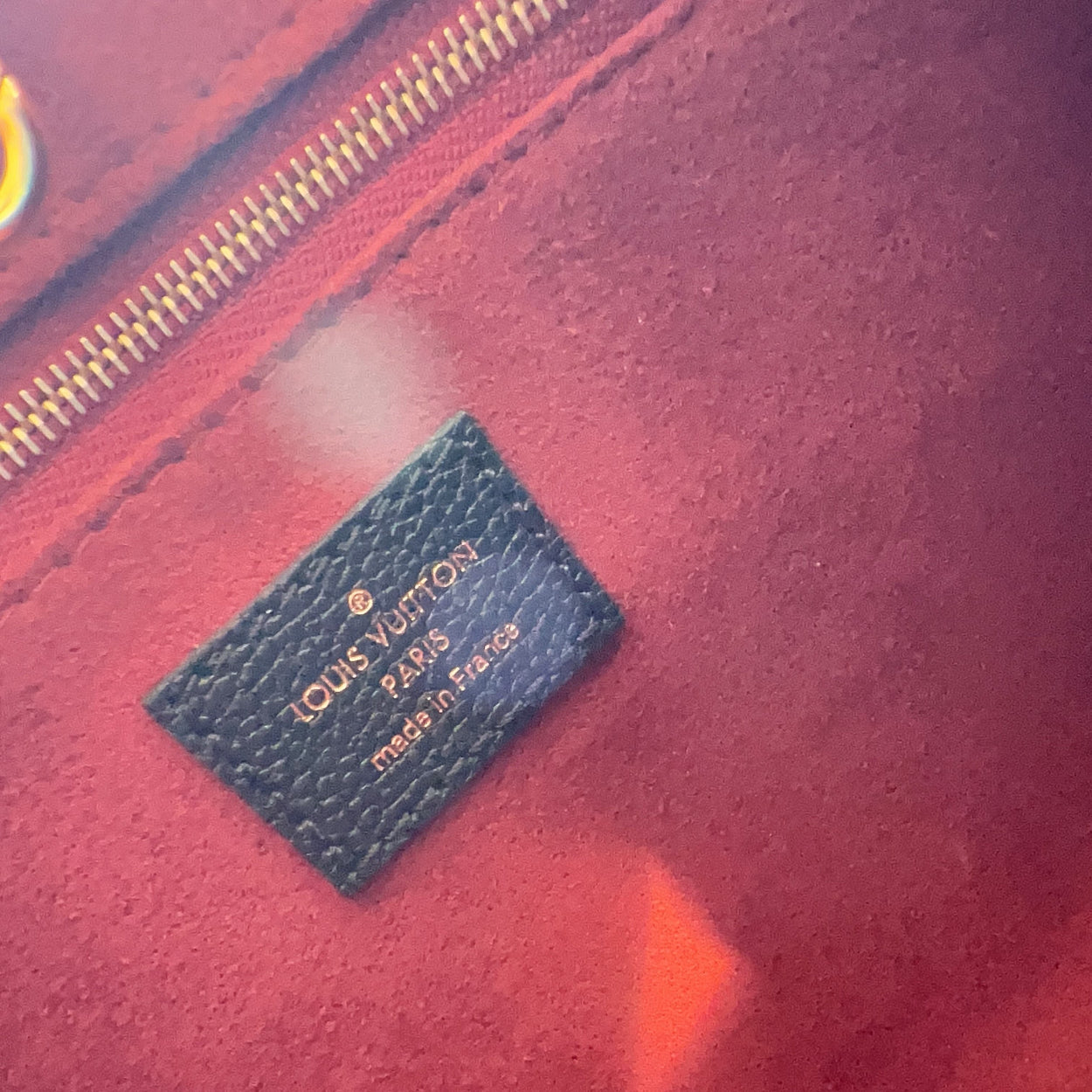 Louis Vuitton label on a red textured surface