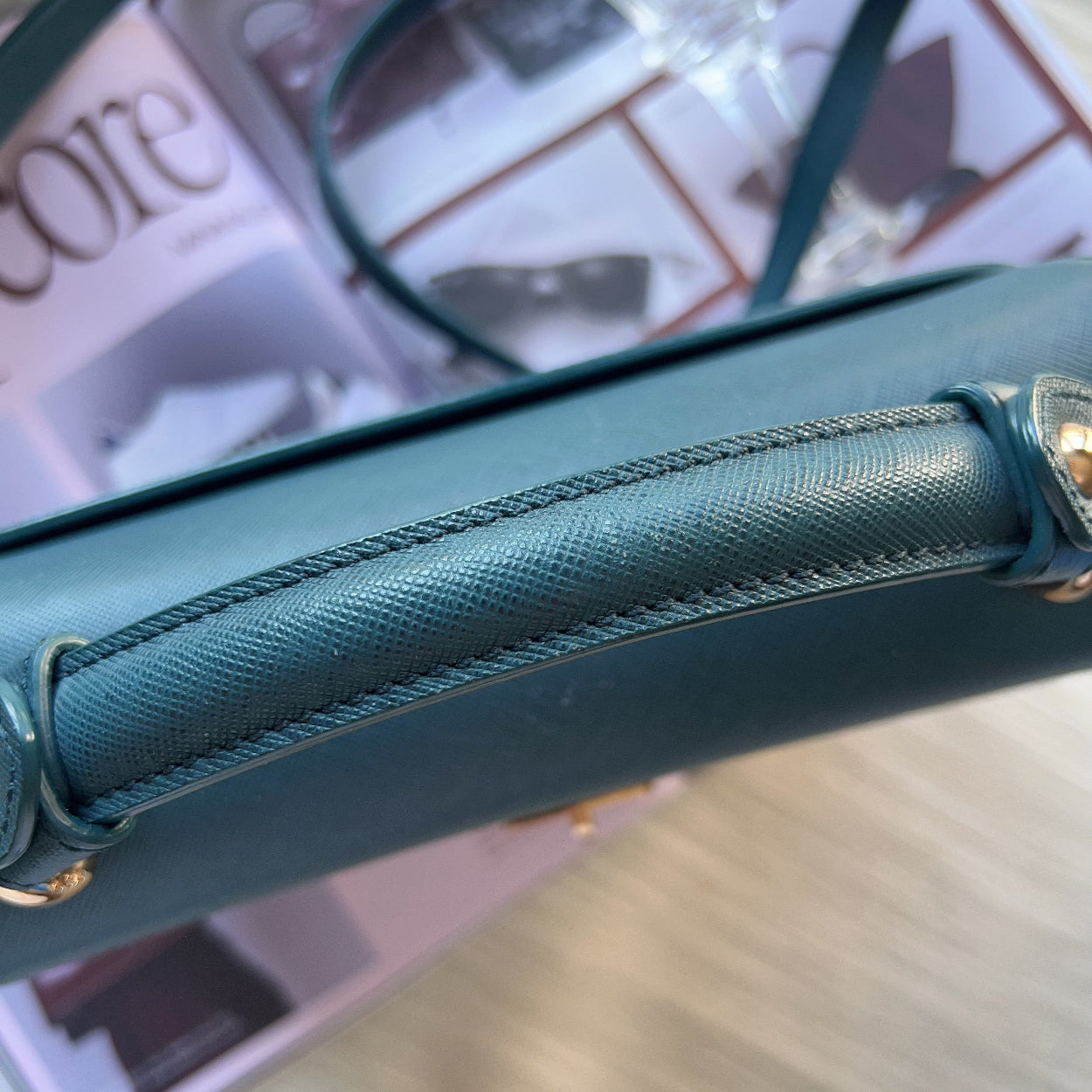 Close-up of a teal handbag with a blurred background