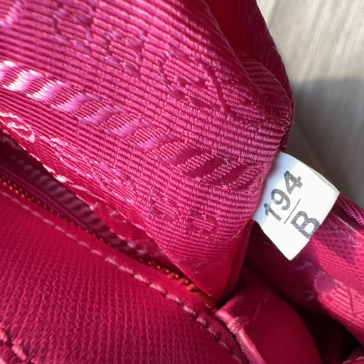Close-up of a pink textured bag with a visible tag.