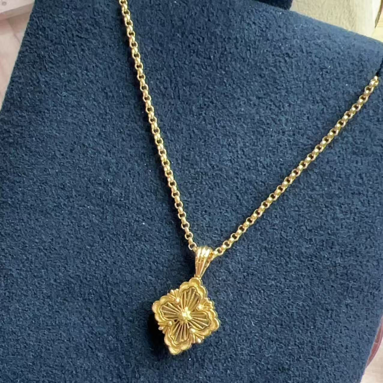 Gold necklace with a floral pendant on a blue background