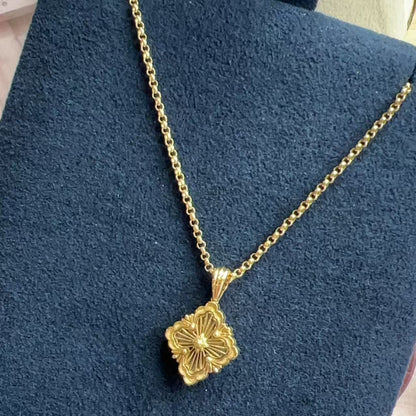 Gold necklace with a floral pendant on a blue background