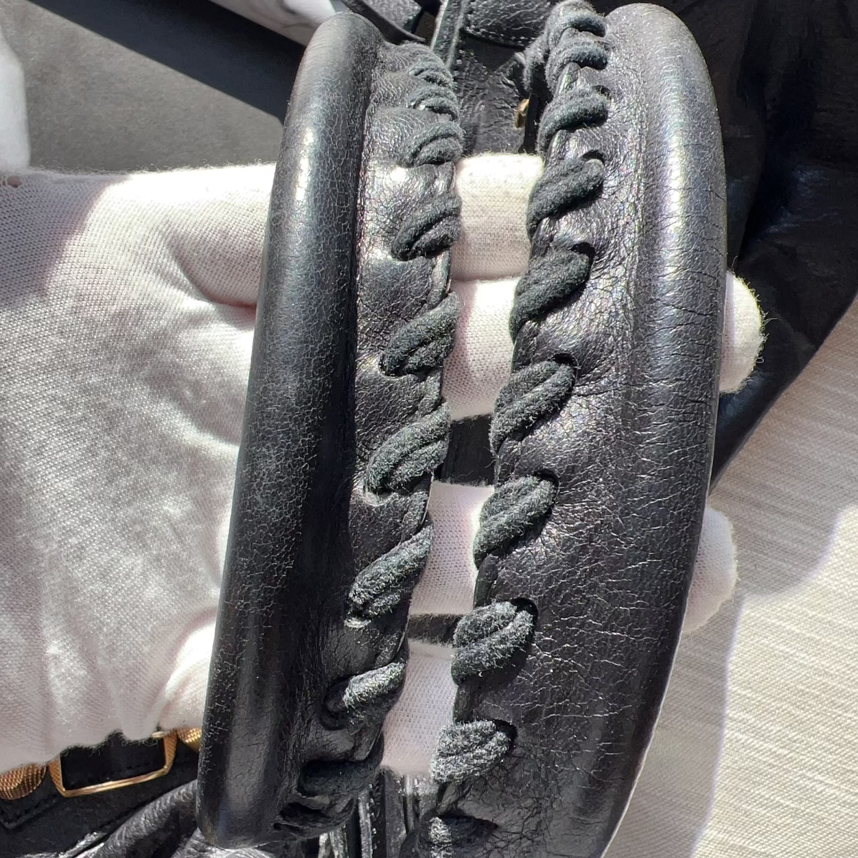 Close-up of a black sandal with braided design on a light-colored surface.