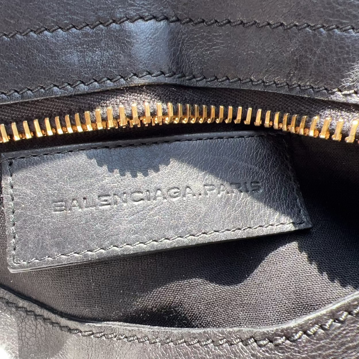 Close-up of a Balenciaga bag with a gold zipper.