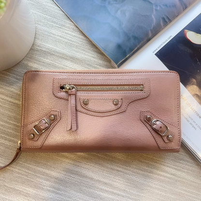 Pink handbag on a textured surface with a blurred background