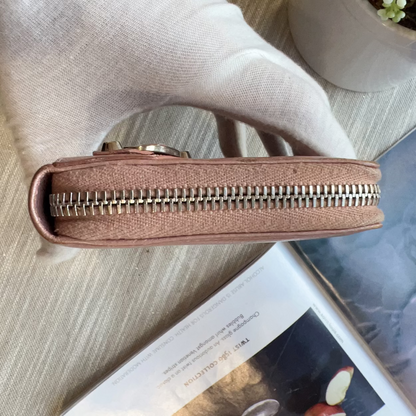 Brown leather wallet with gold zipper on a surface