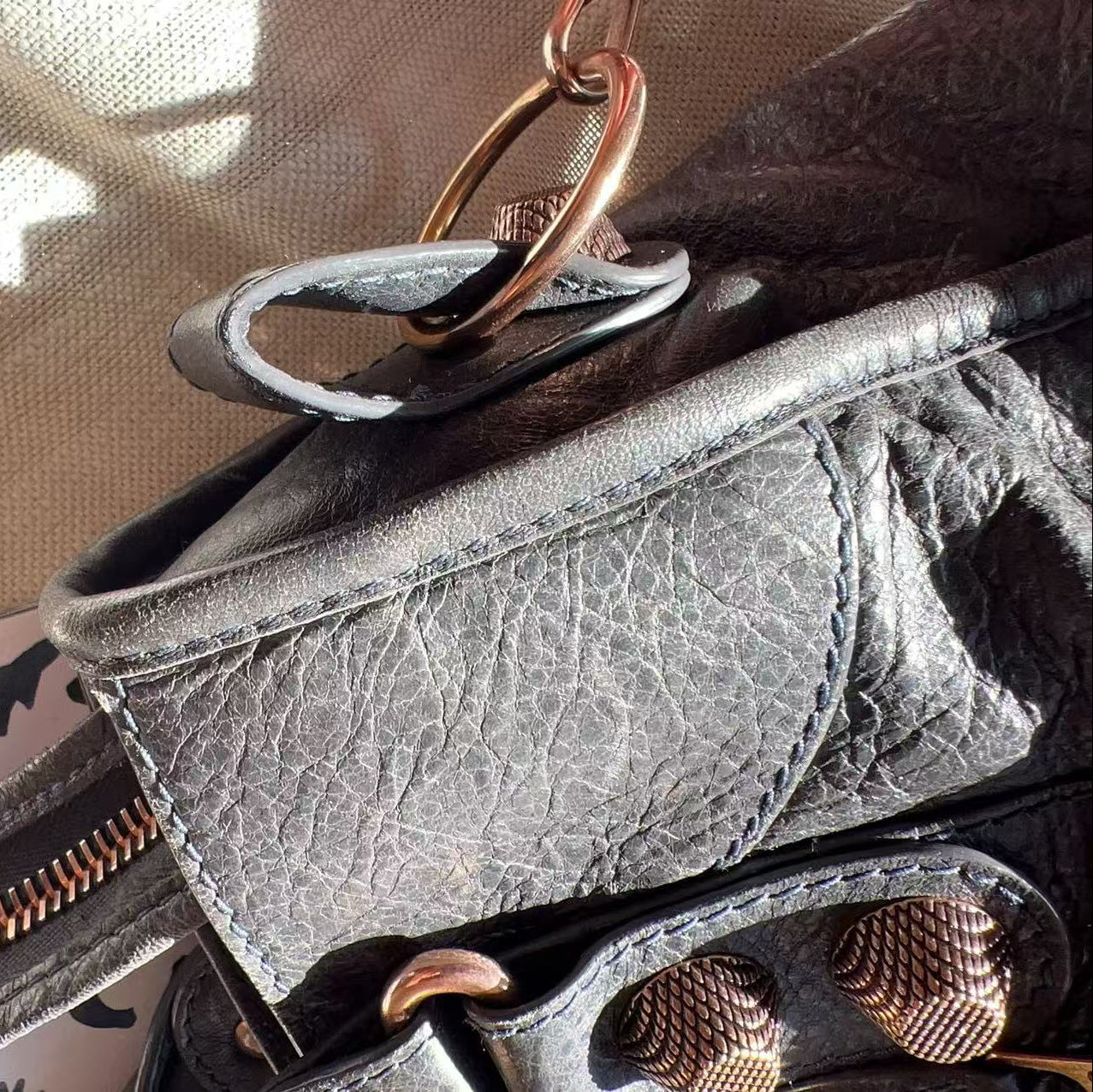 Close-up of a black leather wallet with gold accents on a reflective surface