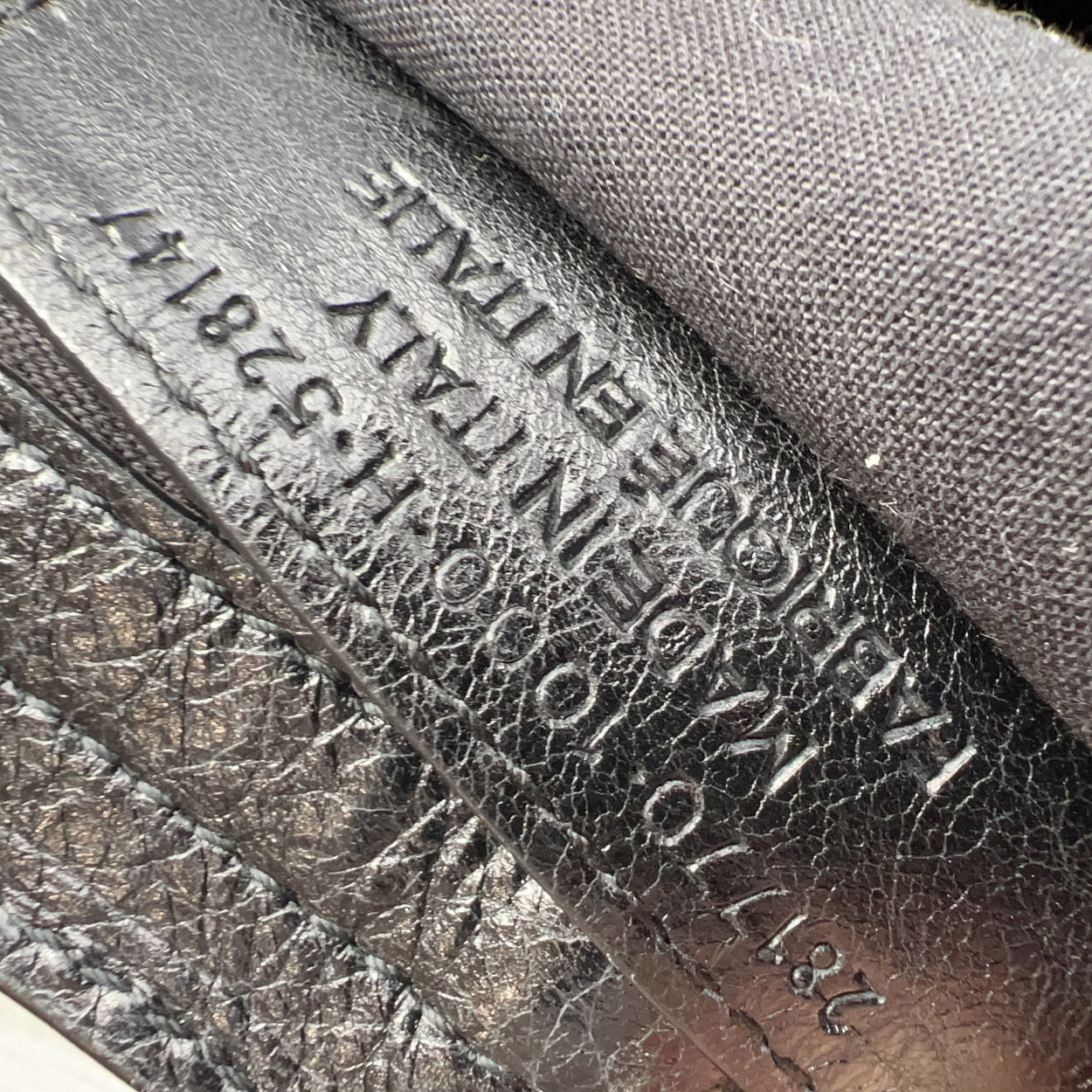 Close-up of a leather product with embossed text and patterns