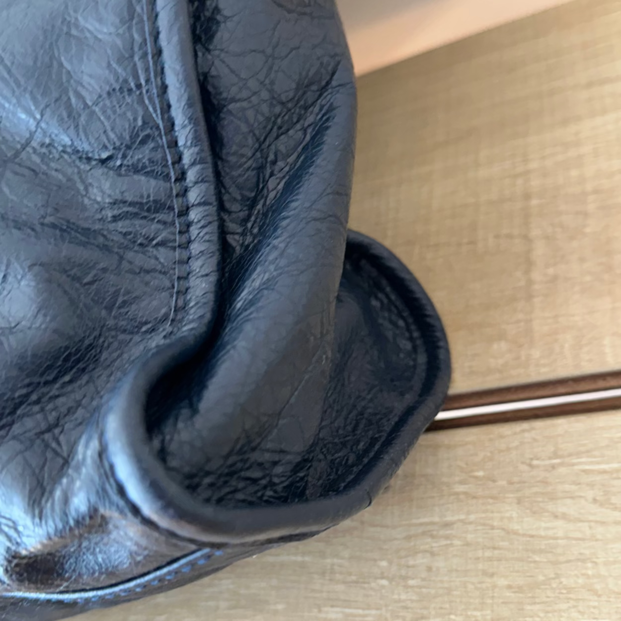 Close-up of a black leather glove on a wooden surface