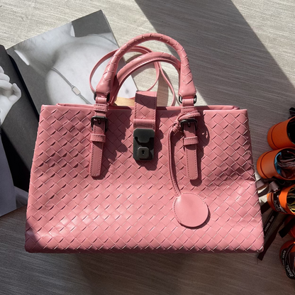 Pink woven handbag on a light wooden surface
