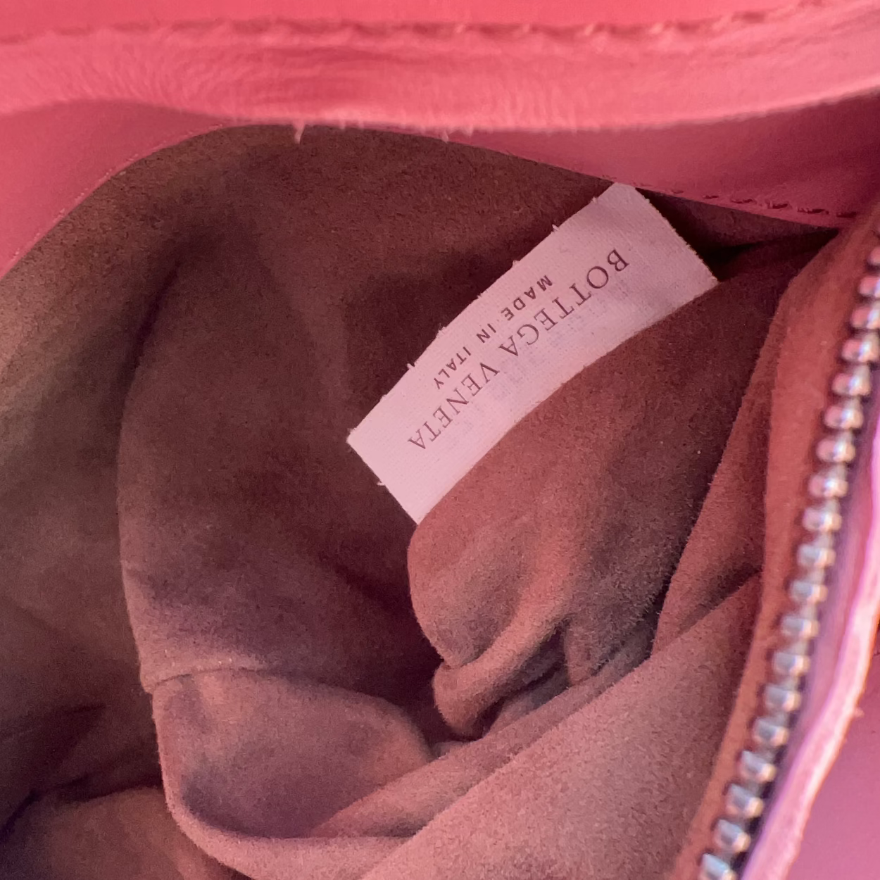 Close-up of a Bottega Veneta label inside a pink fabric item.