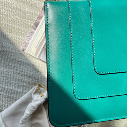 Teal handbag on a textured surface