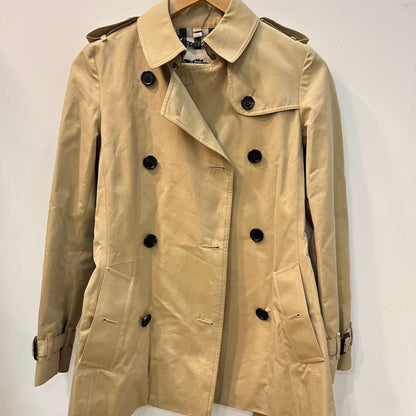 Beige trench coat on a hanger against a white background