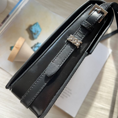 Black handbag with a brand logo on a light surface