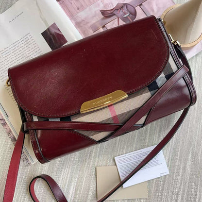 Brown leather handbag with a visible brand logo on a surface with papers underneath