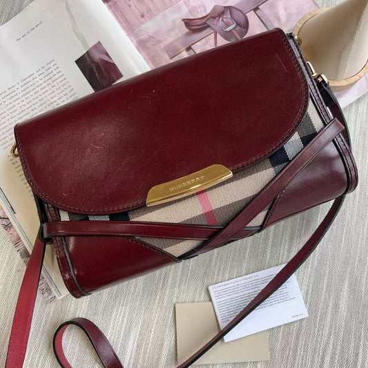 Brown leather handbag with a visible brand logo on a surface with papers underneath