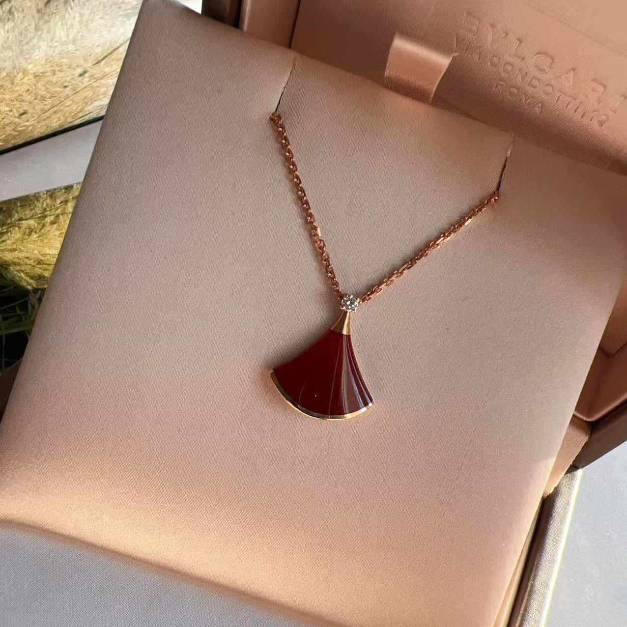 Necklace with a red pendant on a pink jewelry box
